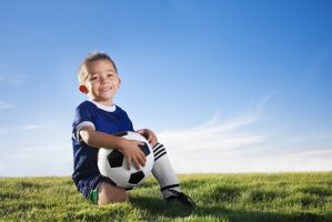 Portrait of a young boy wearing a soccer uniform in a field