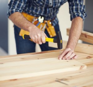 Close up of man hitting nail by hammer